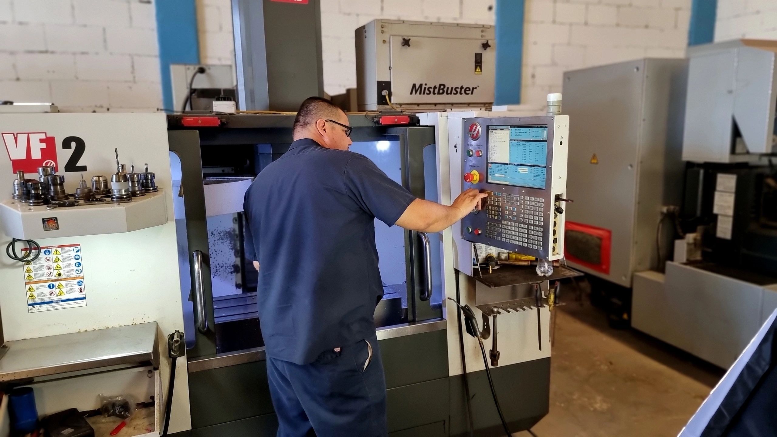 Técnico especializado realizando medición de precisión en Precision Parts & Manufacture